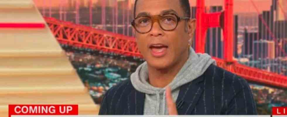 Don Lemon reading the news in a hooded and a suit coat.