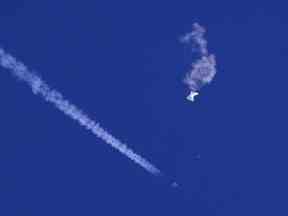 Sur cette photo fournie par Chad Fish, les restes d'un grand ballon dérivent au-dessus de l'océan Atlantique, juste au large de la Caroline du Sud, avec un avion de chasse et sa traînée vue en dessous, le 4 février 2023.