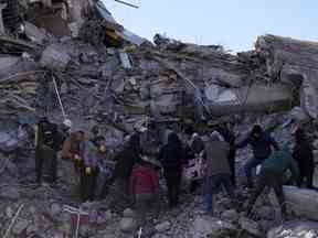 Des personnes transportent un cadavre depuis un immeuble effondré à Kahramanmaras, dans le sud de la Turquie, le mercredi 8 février 2023.