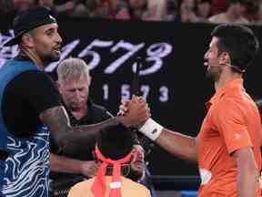 L'Australien Nick Kyrgios, à gauche, et le Serbe Novak Djokovic se serrent la main après un match d'exhibition à la Rod Laver Arena de Melbourne, en Australie, le vendredi 13 janvier 2023.