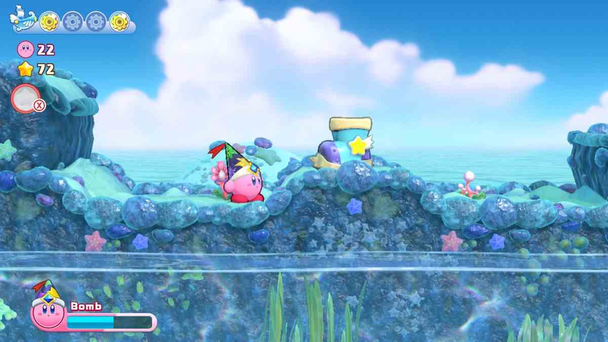 Kirby navigue à la surface d'un monde de récifs coralliens dans Kirby's Return to Dreamland Deluxe
