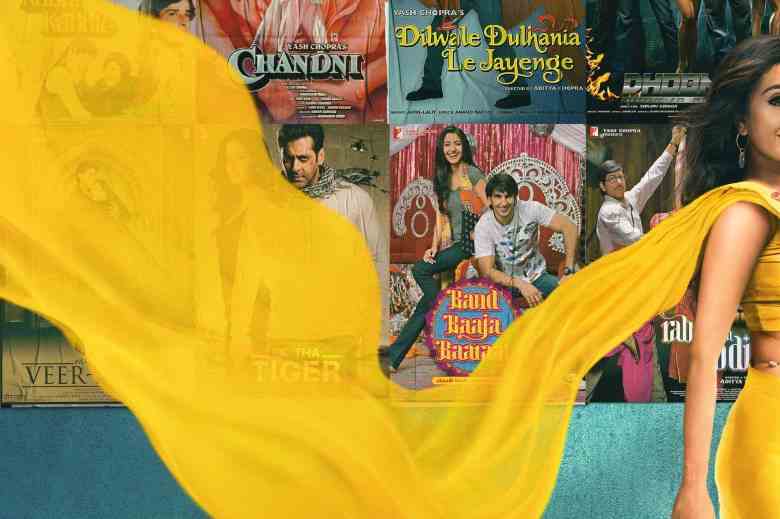La traînée de sari jaune d'une femme passe devant un mur d'affiches de films, y compris "Kabhi Kabhie," Chandni," "Veer-Zaara," "Ek Tha Tigre," "Dilwale Dulhania Le Jayenge," "Groupe Baaja Baaraat," "Doom," et "Rab Ne Bana Di Jodi"