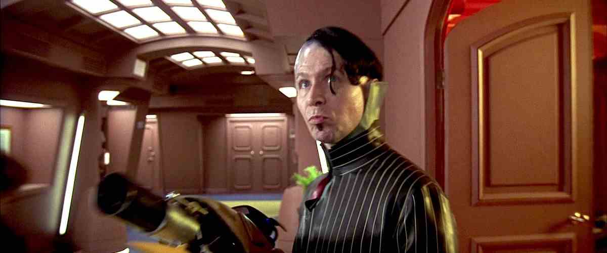 Zorg brandit une arme extraterrestre en prenant d'assaut le couloir d'un hôtel