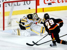 L'attaquant des Flames de Calgary Dillon Dube marque contre le gardien des Bruins de Boston Linus Ullmark au Scotiabank Saddledome de Calgary le mardi 28 février 2023.