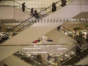 Les acheteurs empruntent les escalators d'un magasin Nordstrom au centre-ville de Toronto.  Nordstrom Inc. dit mettre fin à ses opérations canadiennes et fermer tous ses magasins au Canada.