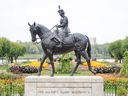 La reine Elizabeth II monte son cheval préféré, une jument noire née en Saskatchewan nommée Burmese, offerte en 1969 par la Gendarmerie royale du Canada.  La pièce a été sculptée par l'artiste de la Saskatchewan Susan Velder