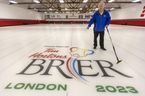 Peter Inch, qui dirigera le Brier, pose avec un logo sur une patinoire associée au St. Thomas Curling Club.  Photographie prise le lundi 20 février 2023. (Mike Hensen/The London Free Press)