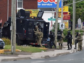 Des agents d'intervention d'urgence entrent dans une résidence à Moncton, au Nouveau-Brunswick, le jeudi 5 juin 2014.