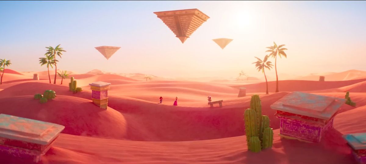 Une photo de paysage du royaume de sable du film Super Mario Bros.  Mario, Peach et Toad traversent une dune de sable à l'arrière-plan.