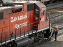 Un employé monte à bord d'une locomotive du Chemin de fer Canadien Pacifique dans un triage à Calgary.