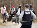 Des demandeurs d'asile entrent au Canada depuis la frontière américaine près d'un poste de contrôle sur le chemin Roxham près d'Hemmingford, au Québec, le 24 avril 2022.