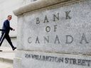 Le gouverneur de la Banque du Canada, Tiff Macklem, marche devant l'édifice de la Banque du Canada à Ottawa.