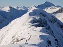 Les skieurs de l'arrière-pays sont éclipsés par les montagnes alors qu'ils progressent le long d'une crête près de McGillivray Pass Lodge situé dans le sud des montagnes Chilcotin en Colombie-Britannique. Le mardi 10 janvier 2012. Avalanche Canada confirme que deux skieurs ont été attrapés et blessés dans des glissements séparés Pemberton.