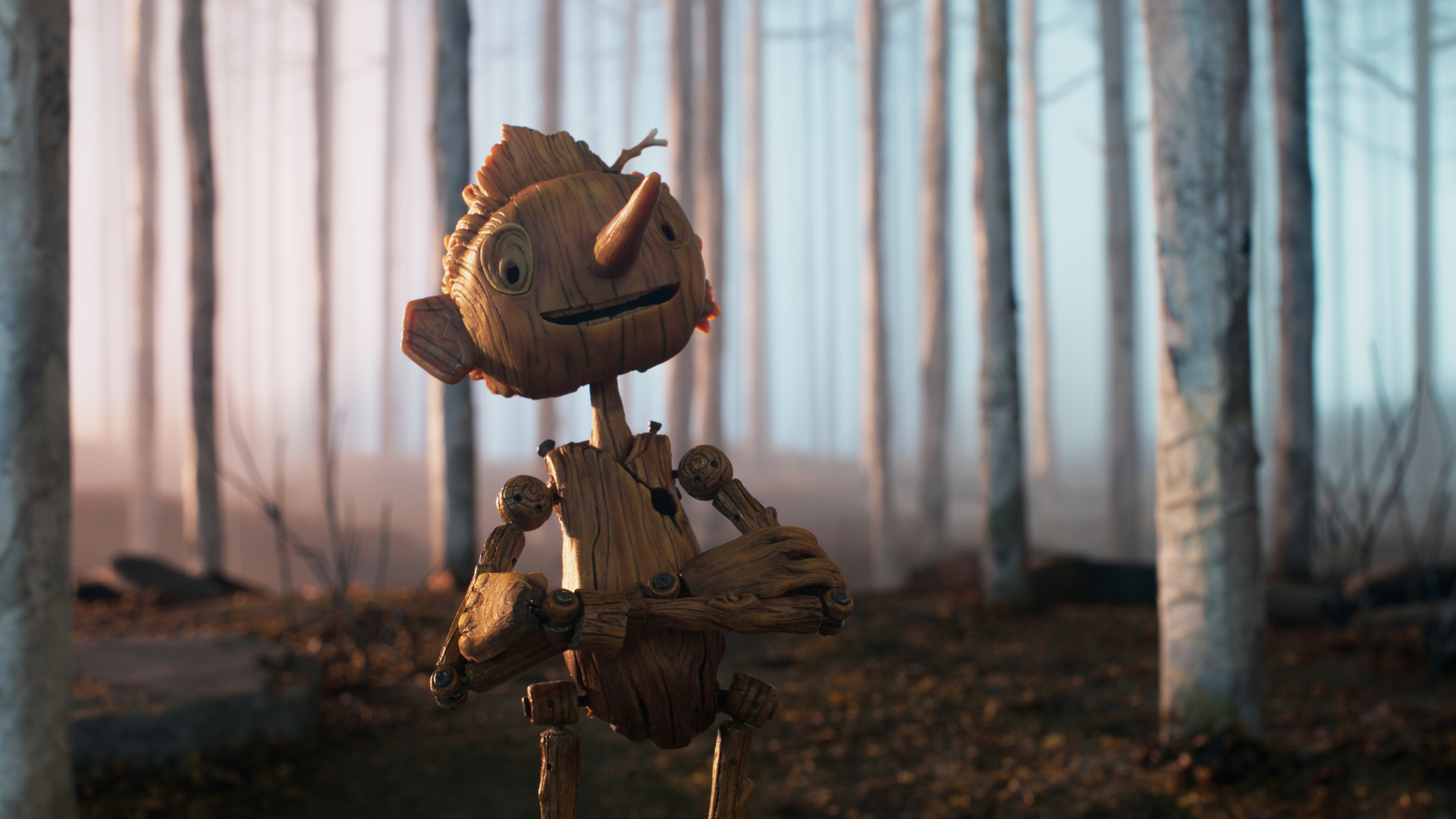 Pinocchio sourit en croisant les bras dans une forêt dans l'adaptation cinématographique en stop-motion de Guillermo del Toro pour Netflix