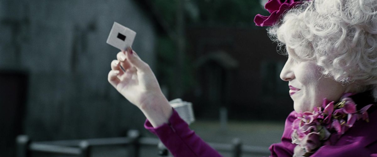 Effie Trinket tient un bout de papier à la Moisson, filmé dans le film The Hunger Games. 