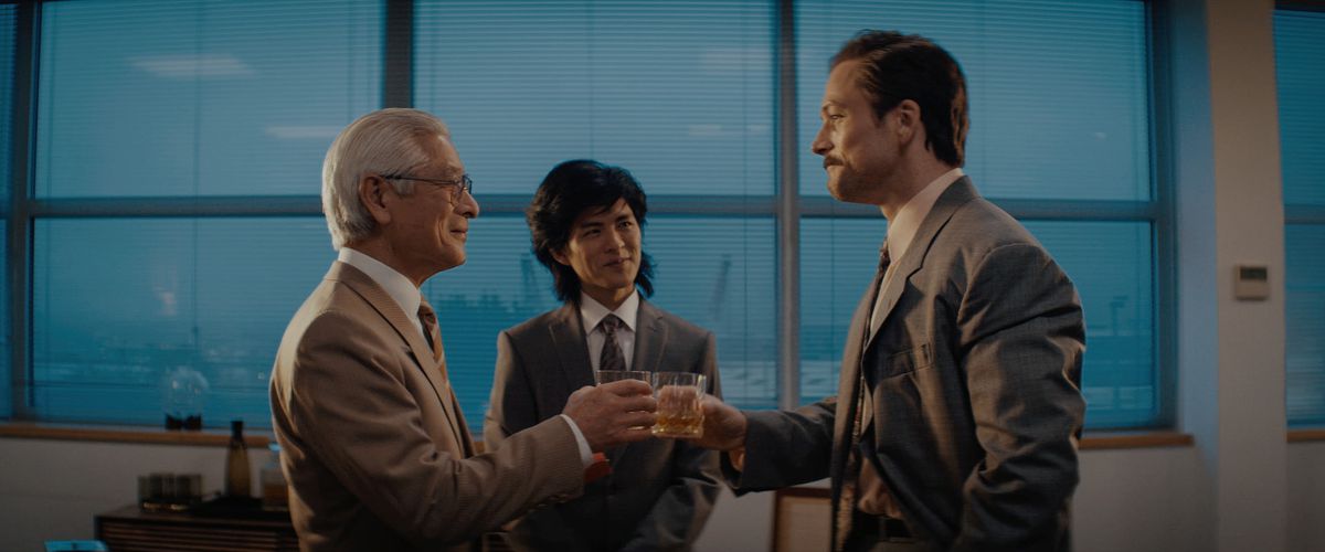 Togo Igawa dans le rôle de Hiroshi Yamauchi et Taron Egerton dans le rôle de Henk Roger se portent un toast dans une image du film Tetris.