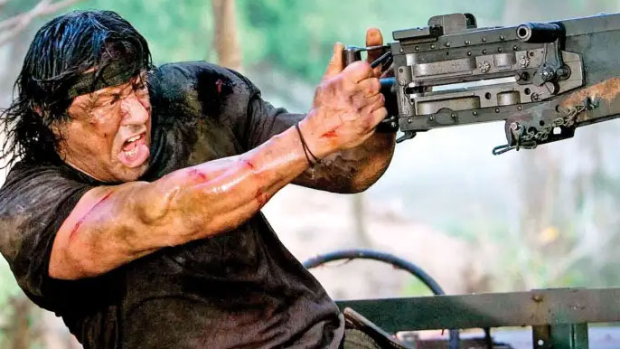 Sylvester Stallone dans le rôle de Rambo, tenant une arme à feu et l'air en colère