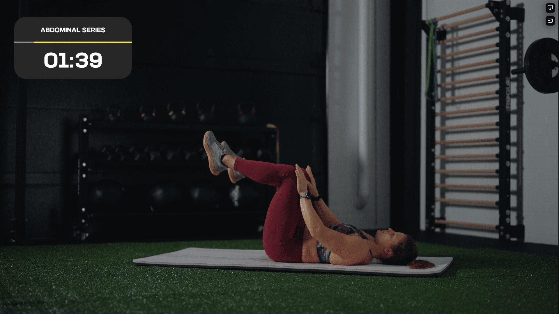 Image de Laura sur le dos sur un tapis d'exercice avec les genoux pliés en l'air effectuant un étirement du bas du dos