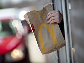 Un employé remet une commande à un client au service au volant d'un McDonald's dans l'Illinois.