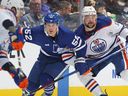Devin Shore des Oilers d'Edmonton patine contre Noel Acciari des Maple Leafs de Toronto lors d'un match de la LNH au Scotiabank Arena le 11 mars 2023 à Toronto.