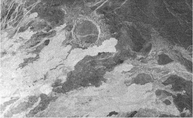 Image radar Magellan de 140 km de large de Vénus montrant des coulées de lave (brillantes car rugueuses) qui ont commencé à empiéter sur un cratère d'impact plus ancien.