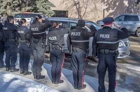 Les policiers ont rendu hommage à leurs collègues décédés alors qu'ils étaient transportés au bureau des médecins légistes par une escorte de la police, des pompiers et des SMU le 16 mars 2023 à Edmonton.