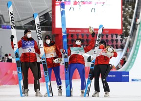 Mackenzie Boyd-Clowes, Abigail Strate, Matthew Soukup et Alexandria Loutitt d'Équipe Canada célèbrent leur médaille de bronze lors de la ronde finale de saut à ski par équipes mixtes au Centre national de saut à ski l'an dernier.