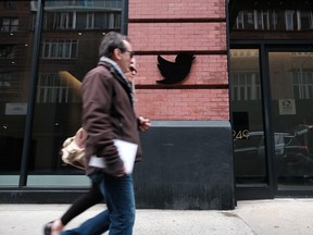 Des gens passent devant le siège social de Twitter à Manhattan.