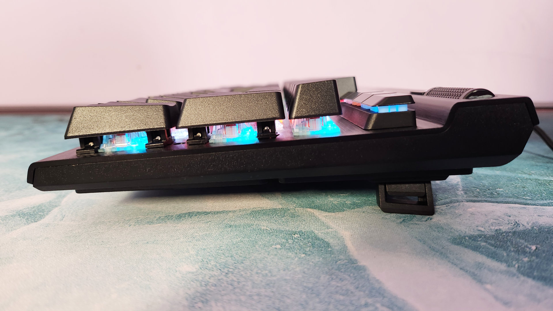 Corsair K70 RGB Pro review : Une vue latérale d'un clavier de jeu, mettant en valeur ses pieds rétractables et son éclairage RVB