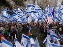 Des manifestants assistent à une manifestation massive devant le parlement israélien alors que les dirigeants de l'opposition appellent à une grève nationale et à des manifestations dans tout le pays contre le gouvernement israélien à Jérusalem, le 13 février 2023.