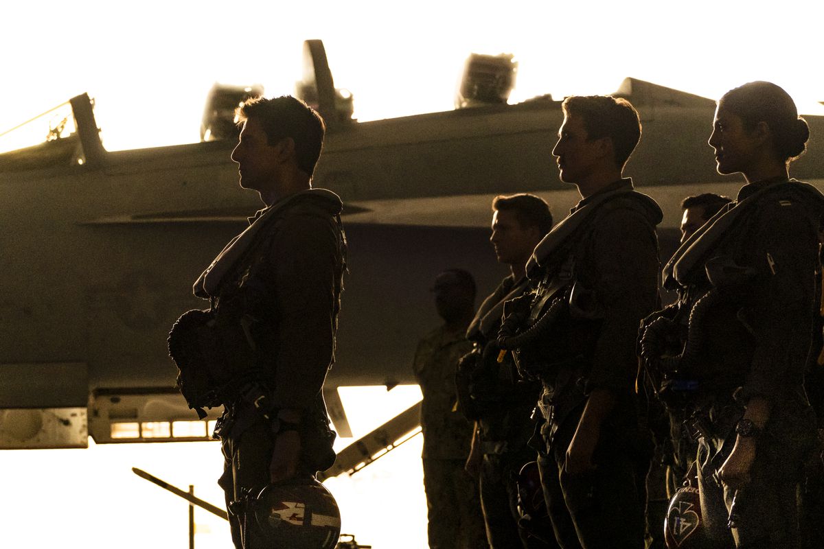 Maverick se tient de profil avec sa classe de jeunes mâles dans un coucher de soleil dramatique pour Top Gun: Maverick
