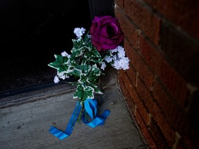 Des fleurs se trouvaient devant la porte d'entrée du complexe d'appartements Baywood, 11445 132 St., le lundi 20 mars 2023, à la suite de la mort par balle du const.  Travis Jordan et Const.  Brett Ryan, à Edmonton jeudi dernier.