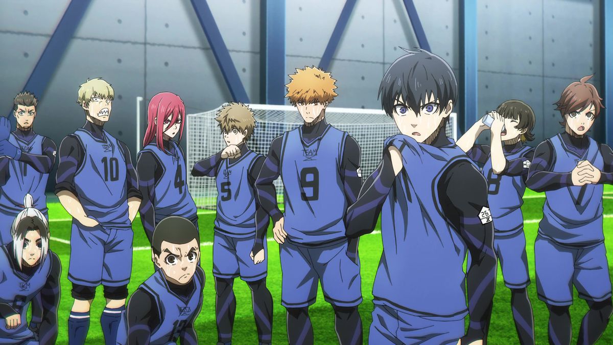 Isagi et son équipe d'origine dans Blue Lock se tiennent sur le terrain de football devant le but.