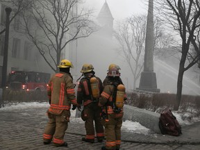 Des pompiers de Montréal sur les lieux d'un incendie sur la rue du Port dans le Vieux-Montréal le 16 mars 2023.