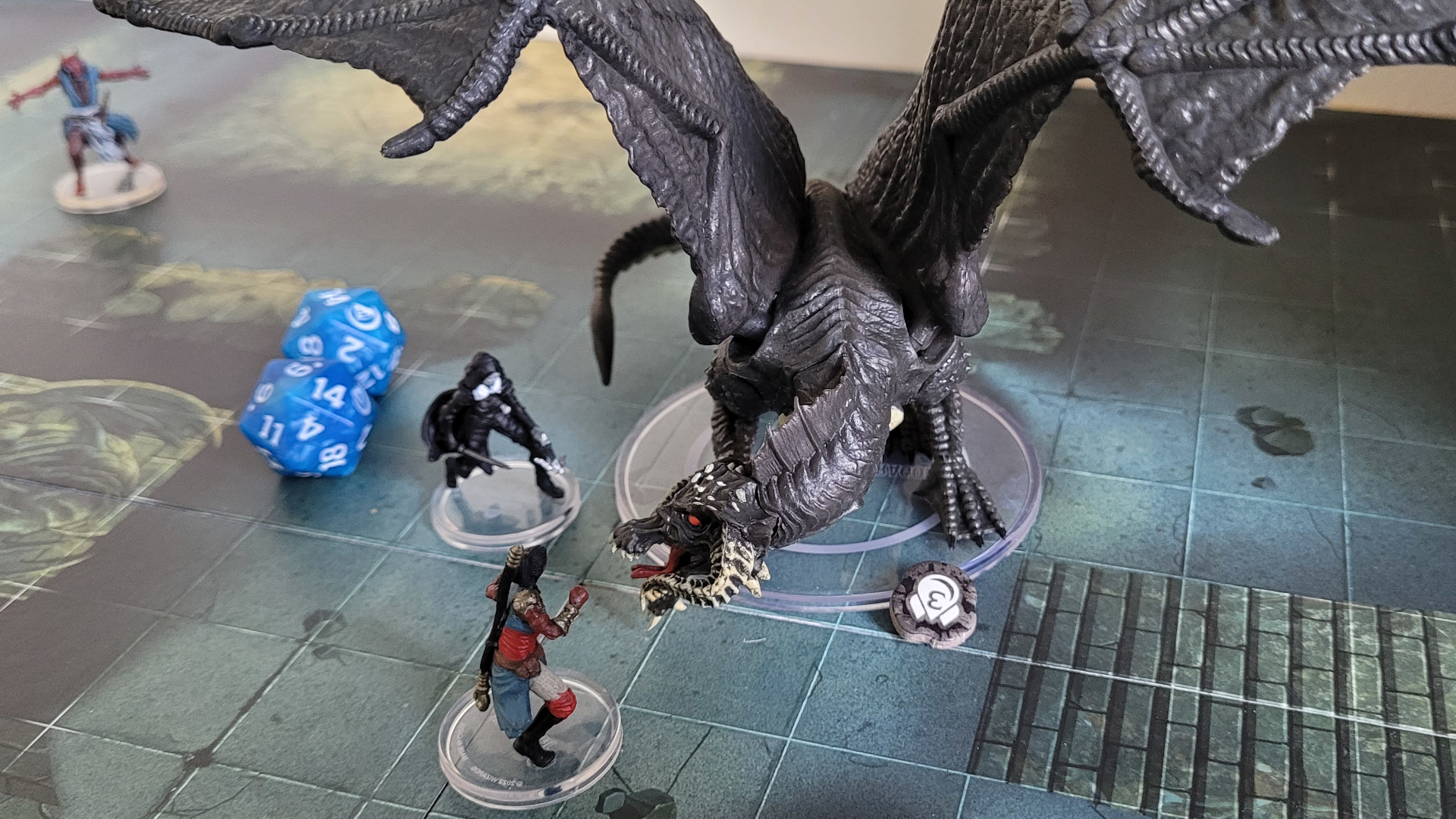 Une figurine de dragon affronte des héros sur le plateau de Dungeons & Dragons : Onslaught