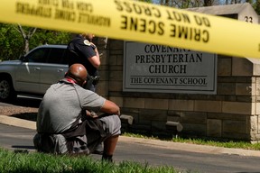 Mario Dennis, l'un des membres du personnel de cuisine de la Covenant School, est assis près d'un policier après une fusillade dans l'établissement de Nashville, Tennessee, le 27 mars 2023.