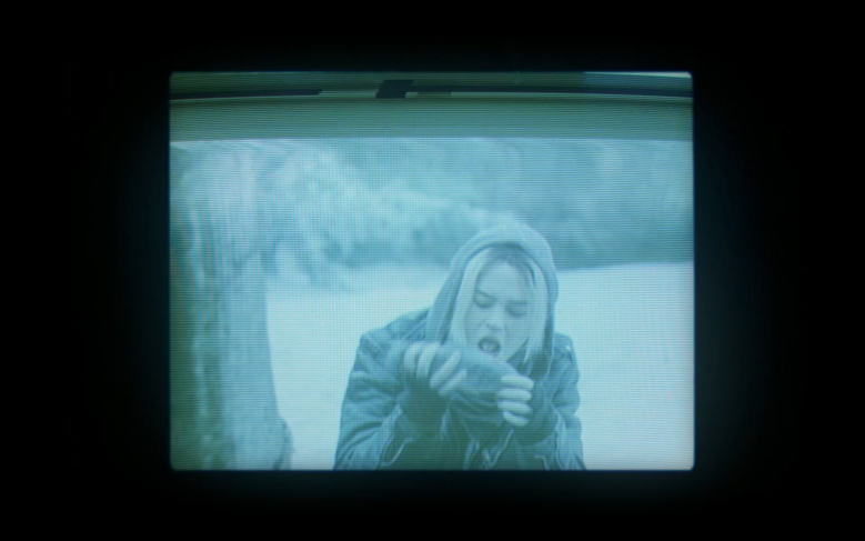 Une adolescente habillée en couches à l'extérieur dans la neige, sur le point de manger quelque chose d'inidentifiable ;  encore de "Vestes jaunes"