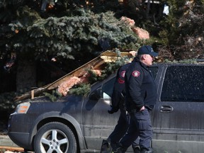 Des enquêteurs marchent à côté de débris sur les lieux d'une explosion sur Maryvale Way NE à Calgary le lundi 27 mars 2023.