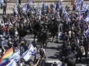 Des officiers de la police montée israélienne dispersent des manifestants bloquant une autoroute lors d'une manifestation contre les projets du gouvernement du Premier ministre Benjamin Netanyahu de refondre le système judiciaire à Tel Aviv, Israël, le jeudi 16 mars 2023.
