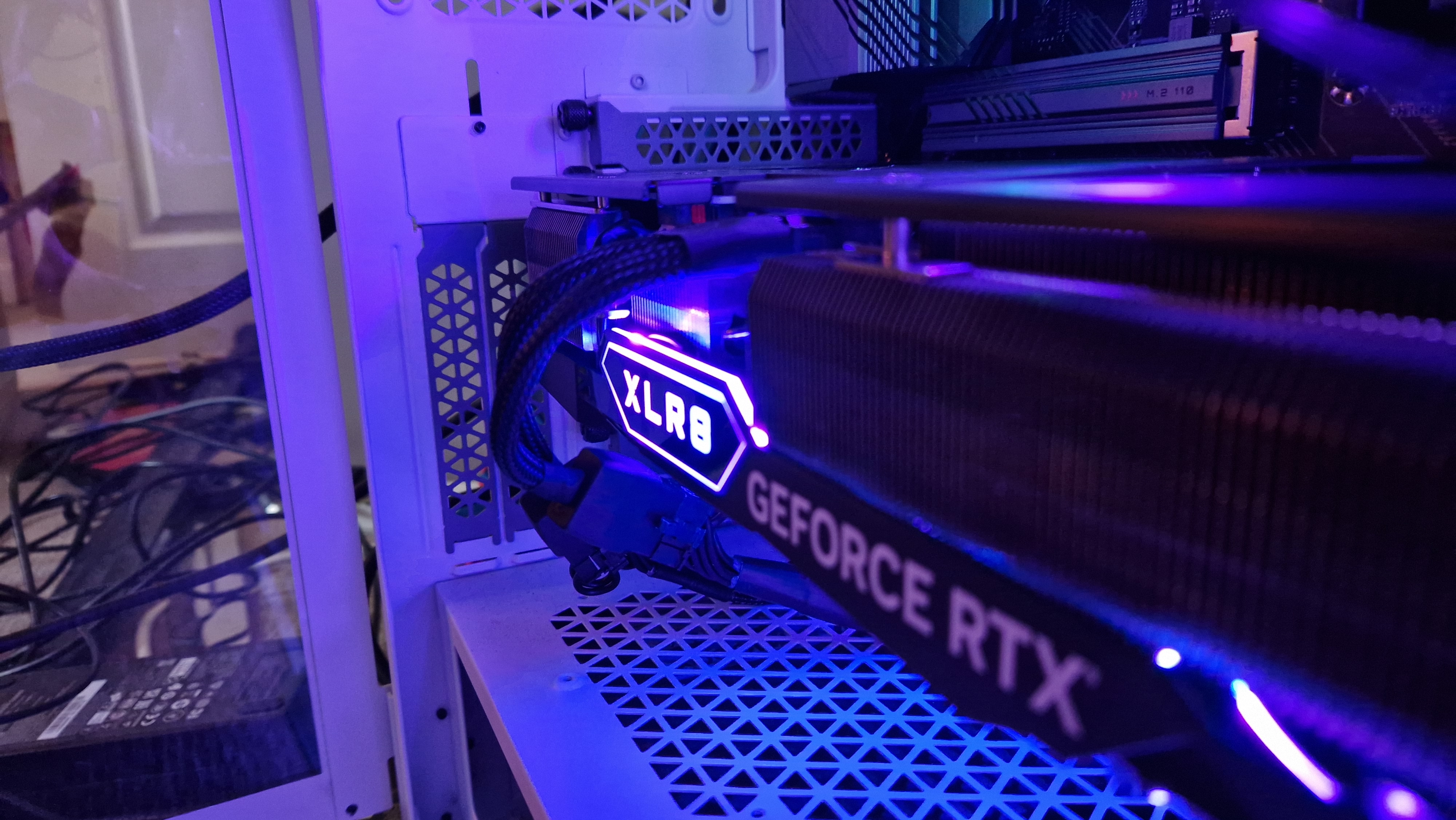 PNY GeForce RTX 4070 Ti à l'intérieur d'un PC de jeu montrant le convertisseur de câble fourni par PNY