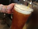 Sur la photo, un barman remplit un pichet de bière dans un pub du centre-ville de Vancouver, en Colombie-Britannique, le 25 juillet 2014.