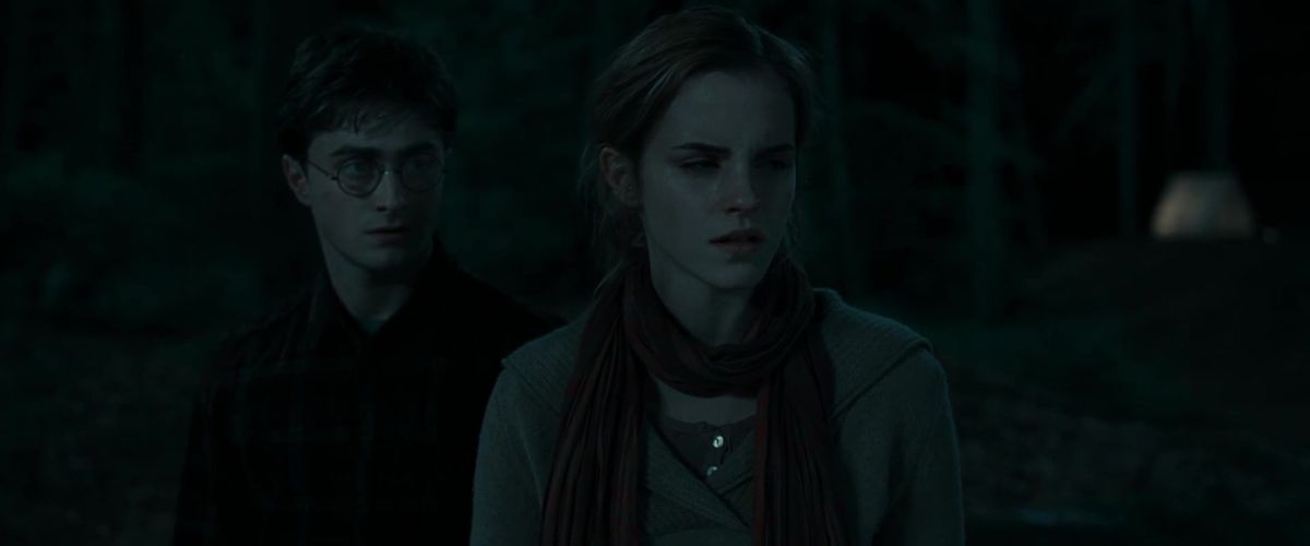 Harry Potter (Daniel Radcliffe) se place derrière Hermione (Emma Watson) dans un cliché sombre, sombre et difficile à analyser de Harry Potter et les Reliques de la Mort – Partie 1