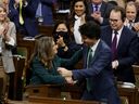 Le premier ministre Justin Trudeau, au centre droit, embrasse la ministre des Finances Chrystia Freeland, au centre gauche, alors qu'elle présente le budget fédéral à la Chambre des communes le 28 mars.