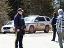 Un agent de la GRC s'entretient avec un homme après que la police a terminé sa recherche du tireur de masse Gabriel Wortman, à Portapique, en Nouvelle-Écosse, le 19 avril 2020. 