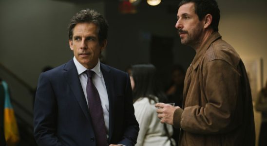 Ben Stiller and Adam Sandler standing together at a party in The Meyerowitz Stories (New and Selected).