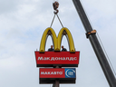 Les travailleurs utilisent une grue pour démanteler les Golden Arches de McDonald's tout en retirant la signalisation du logo d'un restaurant avec service au volant dans la ville de Kingisepp dans la région de Leningrad, en Russie, au printemps dernier.