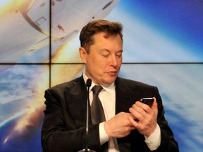 Elon Musk regarde son téléphone portable au Kennedy Space Center à Cap Canaveral, en Floride, le 19 janvier 2020.