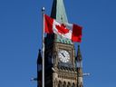 Le drapeau canadien flotte devant la Tour de la Paix sur la Colline du Parlement à Ottawa.