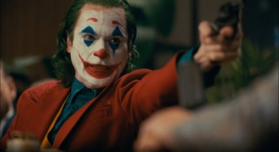Joaquin Phoenix as Joker with a gun