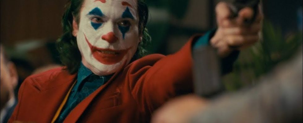 Joaquin Phoenix as Joker with a gun